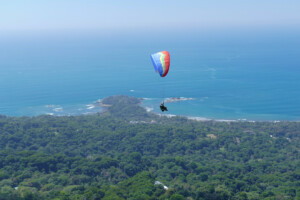 Discover Paragliding Tour one, high in the sky over the Dominical launch. Beach in the background.