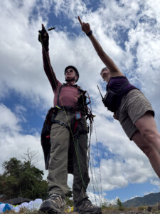 Tow Pilots pointing at the sky as a vulture fly's above.