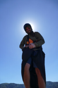 Looking up at a paraglider pilot getting ready to launch.
