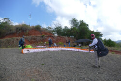 Paraglider pilot on launch, checking downhill before inflation and launch