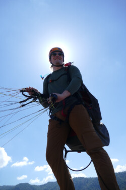 Ready to go! Paraglider pilot ready for launch. One of Brads favorite camera angles, with the sun behind the pilot.